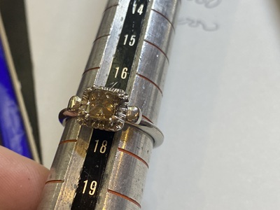 サイズ棒に通したリングにコニャックダイヤモンドが留められた写真