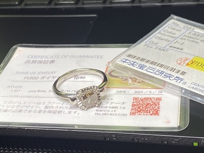 鑑別書の上に置かれた完成リングの写真