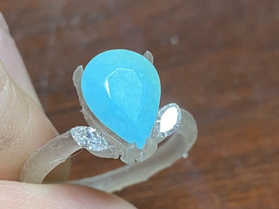 3Dプリントした原形にトルコ石＆ダイヤモンドをセット。リングの細部を作業中に確認している様子