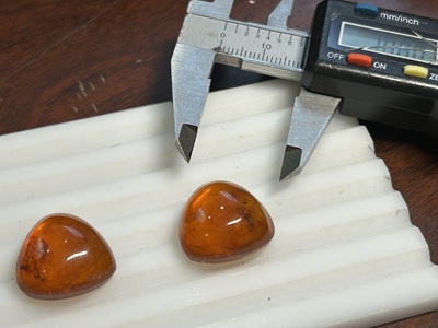 ノギスで琥珀のサイズを計測している写真