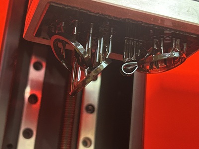 3Dプリンター内部でリングとペンダントの原型が造形されている写真