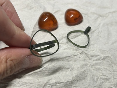 元の枠から外した琥珀と3Dプリントした枠パーツを並べ、形状の確認をしている場面です。石の輪郭に無理なく寄り添う枠にするため、細部の調整を重ねていきます。枠パーツを並べた写真