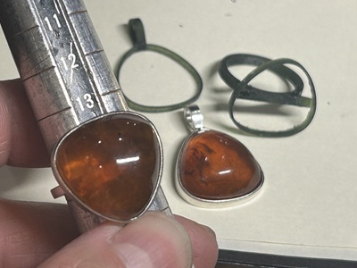 琥珀を新しい枠に仮合わせしたリングとペンダントの途中工程写真