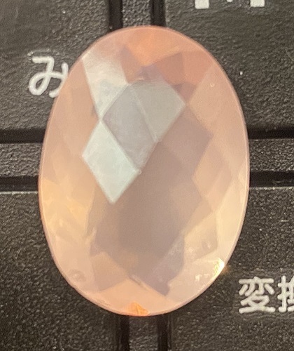 黒いキーボードの上に置かれた、大粒で淡いピンク色のチェッカーボードカット・ローズクォーツ。