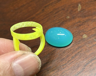3Dプリントされた樹脂原型リングとブルーカルセドニーのルースを並べた写真