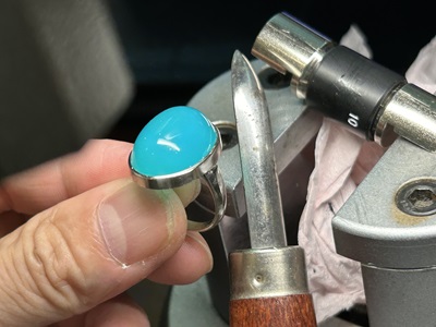 完成したプラチナ製のリング枠にブルーカルセドニーを留める途中工程の写真