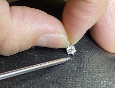 金属の枠にダイヤモンドをセッティングしている作業風景