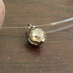 繊細なシースルーネックレスに通された完成品のペンダント。