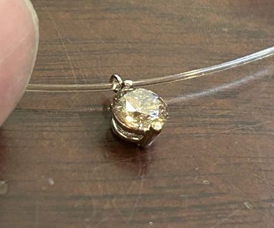 繊細なシースルーネックレスに通された完成品のペンダント。