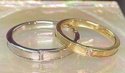 完成した二本のオリジナル結婚指輪が、柔らかな光の中で美しく並んでいる様子