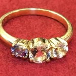 完成したK18 3石ストレートリング。中央の紫の石と両脇の透明な石が美しく輝いている