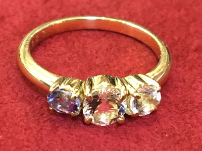 完成したK18 3石ストレートリング。中央の紫の石と両脇の透明な石が美しく輝いている