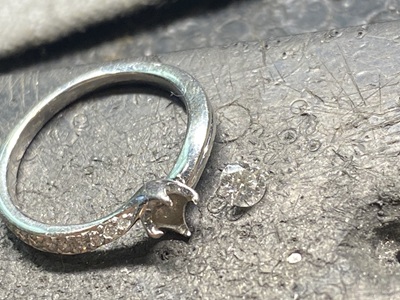 リング枠から丁寧に取り外されたダイヤモンドと空の枠