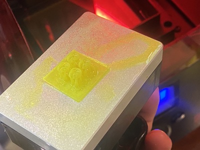 3Dプリンターのプラットフォームに出力された、イエローの樹脂製ペンダント原型