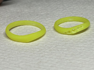 3Dプリンターで出力された、2本の緑色の樹脂製リング原型