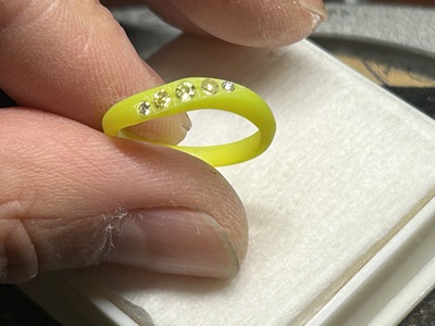 樹脂原型の上に、5つのマルチカラーの宝石を順番に並べて配置している様子