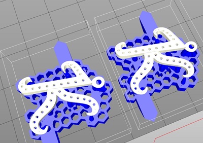 3Dプリンターのスライサーソフト画面。青いハニカム構造のサポート材の上に2つの「K」が配置されている。