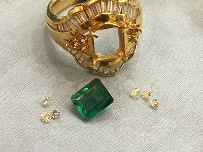 枠から外されたエメラルド1石と、数ピースのメレダイヤモンド