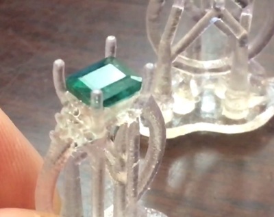 洗浄後の樹脂原型に、実際のエメラルドとダイヤモンドを配置して最終チェックを行っている様子