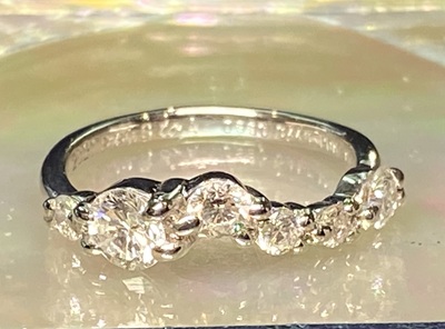 6つのダイヤモンドが流れるような曲線を描いてセットされた、ほぼ完成したリングの側面