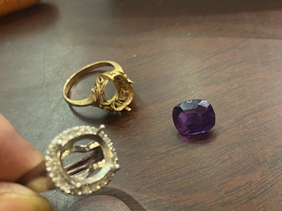 金属で鋳造された直後のリング枠をサイズ棒に通している様子