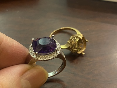 職人が専用の工具を使って金属のリングに宝石をセッティングしている手元