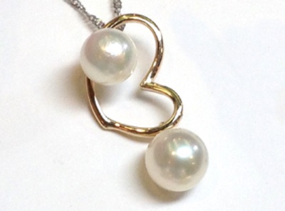 チェーンに通された、K18蝶モチーフと2粒の真珠のペンダント。