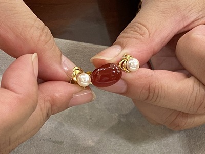 レッドアンバーと真珠を組み合わせたブローチ構成のアップ写真。