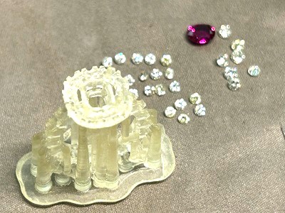 3Dプリンターで出力された樹脂原型に、実際のルビーとダイヤモンドを載せて形状を確認している様子。