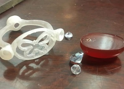 3Dプリントされた樹脂原型と、アンバー、アクアマリン、ダイヤのルースたちが並んでいる様子