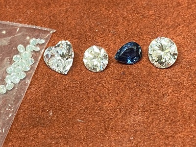 トレイに並べられた4つのメインストーンと、青く輝く複数のパライバトルマリン