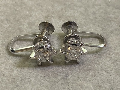 ブルーのトレイに置かれた、一対のネジ式ダイヤモンドイヤリング。