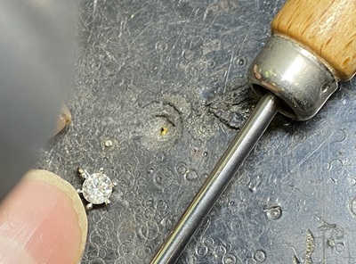 職人の手元。専用工具を使い、ダイヤモンドをプラチナ枠に固定している様子。