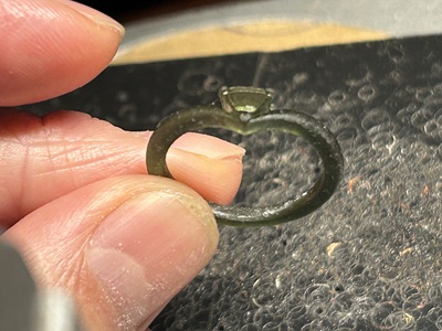 人の手で持たれた、3Dプリントされた樹脂リング。複雑なサポート材が取り除かれた状態。