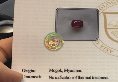 ミャンマー・モゴック産の非加熱ルビーと宝石鑑別書。「Origin: Mogok, Myanmar. Comment: No indication of thermal treatment.」の文字とホログラムシールが写っている。