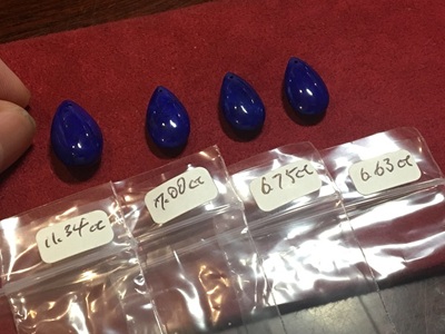 サイズ別に並べられた4石のドロップシェイプラピスラズリ。小袋にはそれぞれの重さが記されている。