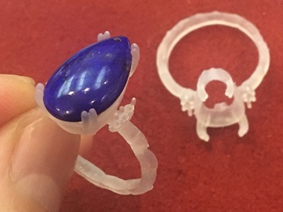 3Dプリンターで出力された、透明感のある樹脂製のリングと石の原型。