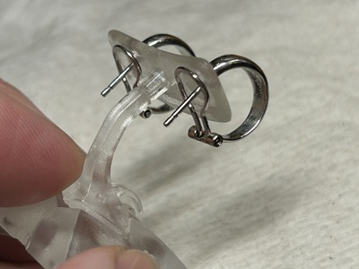 ピアスの裏側から、バネの強さや噛み合わせをピンセット等で調整している細部。