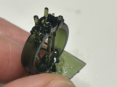 3Dプリンターから取り出された、アームのパヴェ留め用の細かな穴まで精密に再現されたグレーの樹脂製リング原型。