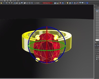 3D CADの操作画面。中央の赤いオーバル石の周囲に青や緑の軸線(ギズモ)が表示され、リング幅とのバランスを調整している様子。