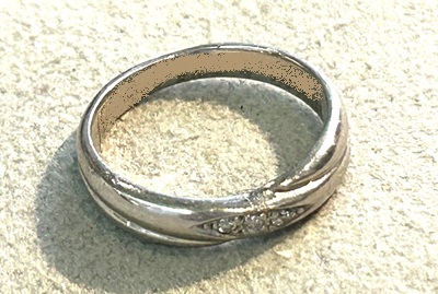 中央にメレダイヤモンドが3ピースセットされた、ウェーブデザインが施されたプラチナの結婚指輪。