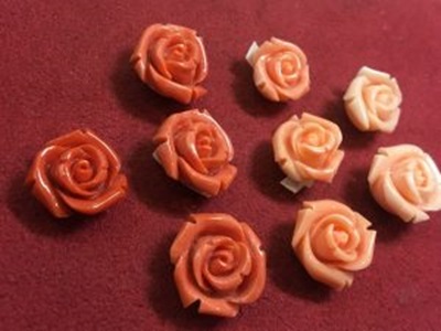 濃い赤から淡いピンクまで、色とサイズ別に並べられた薔薇の形に彫刻された美しい珊瑚のルースたち