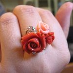 完成した薔薇珊瑚のリングを実際の指にはめ、手元全体がパッと華やいでいる着画（引きのアングル）