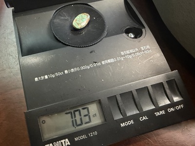 精密秤で測定されているトルコ石（7.03カラット）