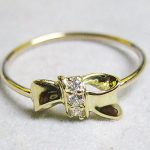 K18金製の細身の丸線にリボンモチーフが接合され、ピカピカに磨き上げられたサイズ9番のゴールドピンキーリング