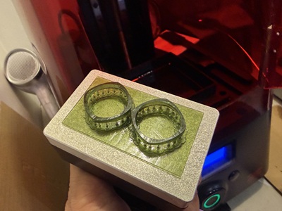 3Dプリンターのビルドプラットフォームに固定された2つのグリーン系の樹脂リング原型