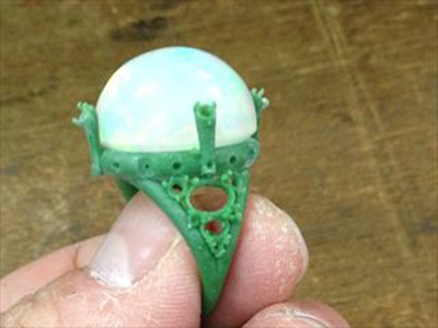 3Dプリンターで出力された緑色の樹脂製リング原型とオパール