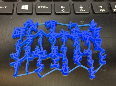 キーボードの上に置かれた、3Dプリンター出力による青い樹脂製の「いろは歌」モデル
