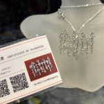 白い首マネキン（トルソー）に着用されたシルバーの「いろは歌」ペンダントと品質保証書