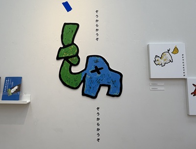壁面に描かれた結び目のついた青と緑のゾウのイラストと「ぞうからかうぞ」の回文テキスト